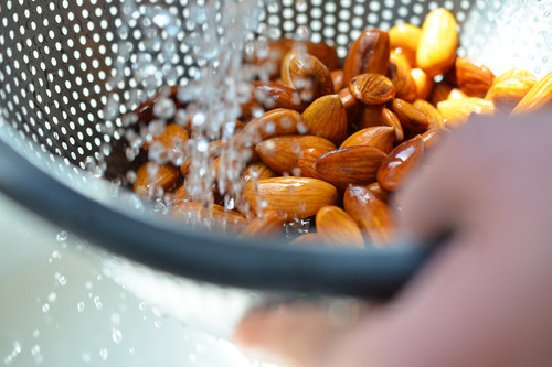 Rinsing the soaked almonds in a colander for vanilla almond milk.