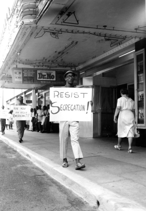 The slow pace of social change in Florida prompted many African-Americans to take action. In this image, dated 1962, young men and women protest outside the Florida Theater in Tallahassee.