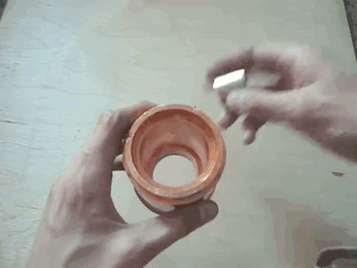 A magnet falling through a copper pipe.