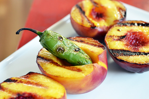 A white platter with the grilled peaches and jalapeño, the ingredients to make a paleo spicy barbecue sauce.