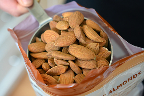 Measuring out one cup of almonds for homemade vanilla almond milk.