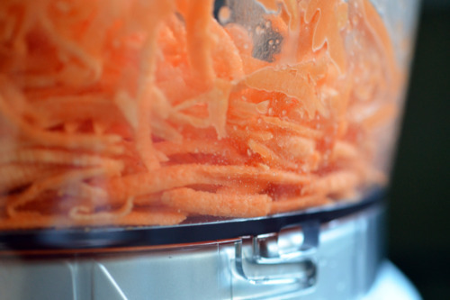 A closeup shot of shredded sweet potato in a food processor.