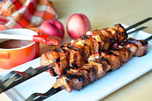 A platter of Peachy Pork-a-Bobs, Whole30-friendly grilled pork skewers with a spicy peach barbecue sauce.