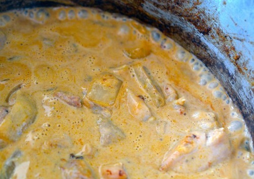 Coconut milk is poured into the healthy Thai Chicken Curry and the stew is brought to a simmer.