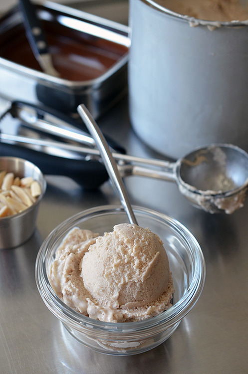 A shot of a scoop of paleo and Dairy-Free Vanilla Ice Cream in front of a dirty ice cream scoop.