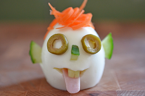 A crazy clown egg that is hardboiled and mimics a face from vegetables.