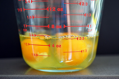 A liquid measuring cup is filled with eggs.