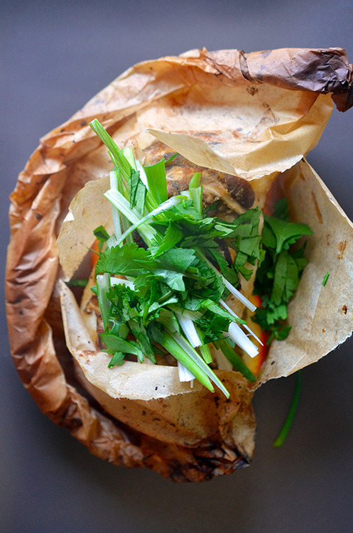 An overhead shot of Fish en Papillote topped with fresh herbs on top.