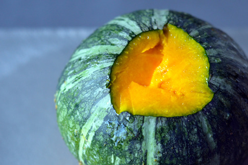An overhead shot of a raw kabocha squash with the stem removed