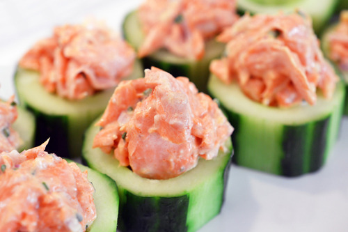Two rows of cucumbers with their seeds taken out, piled on top is the paleo salmon mixture.