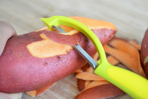 Peeling the skin off a sweet potato.