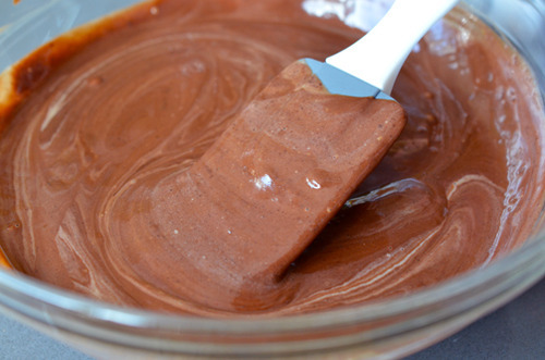 Stirring the ganache for Mexican chocolate pots de crème in a glass bowl.
