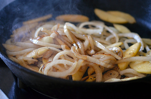 Browned onions and apples in a cast iron skillet.