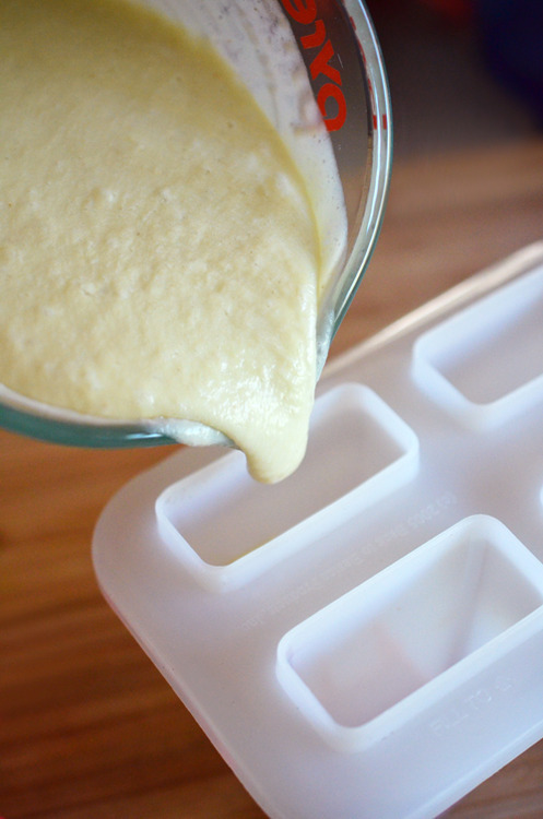 Pouring the pineapple and banana mixture into the ice pop trays.
