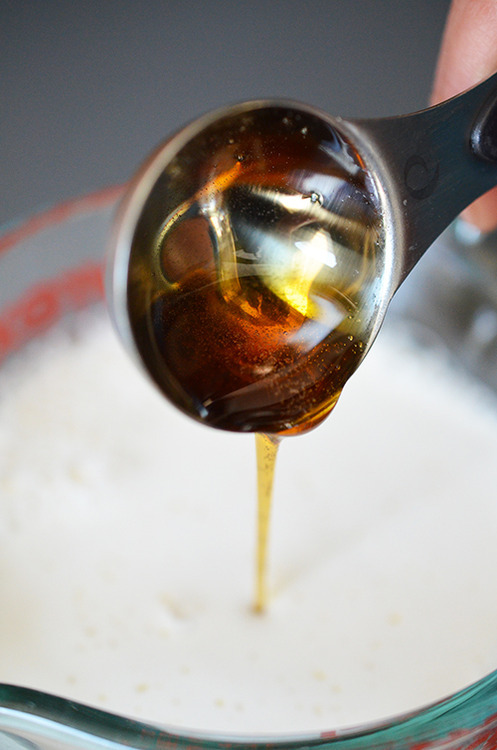 Pouring the measured balsamic vinegar into a glass measuring cup with almond milk.