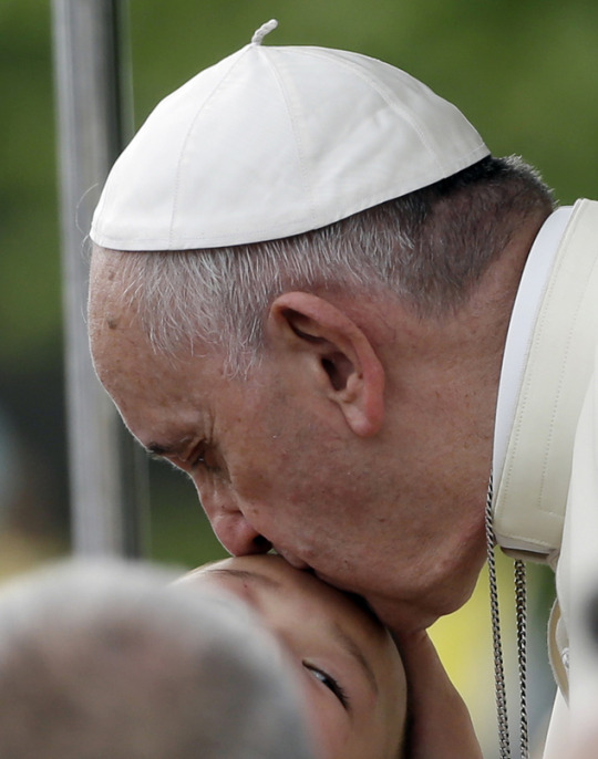 Pope Francis kisses a baby as he arrives at the the "House of Hope" center for disabled in Kkottongnae, South Korea, Saturday, Aug. 16, 2014. Photos: (AP Photo/Gregorio Borgia)