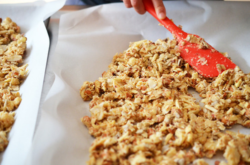Spreading the Tropical Paleo Granola into a single layer before baking them.