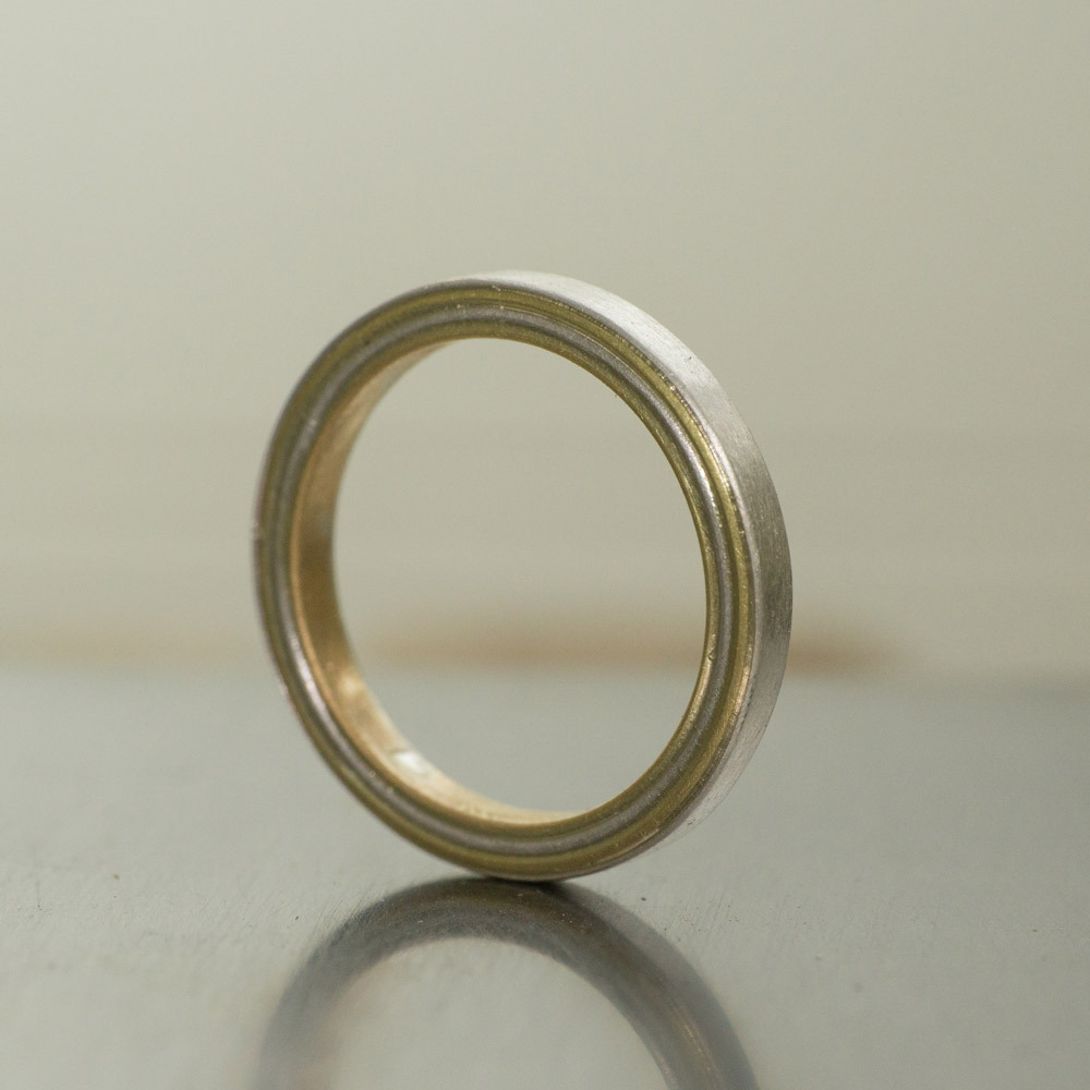 プラチナとゴールドのコンビリング　立てておもて面　作業台の上　屋久島でつくる結婚指輪