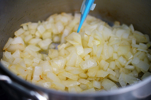 Sautéing chopped onions in a pot.