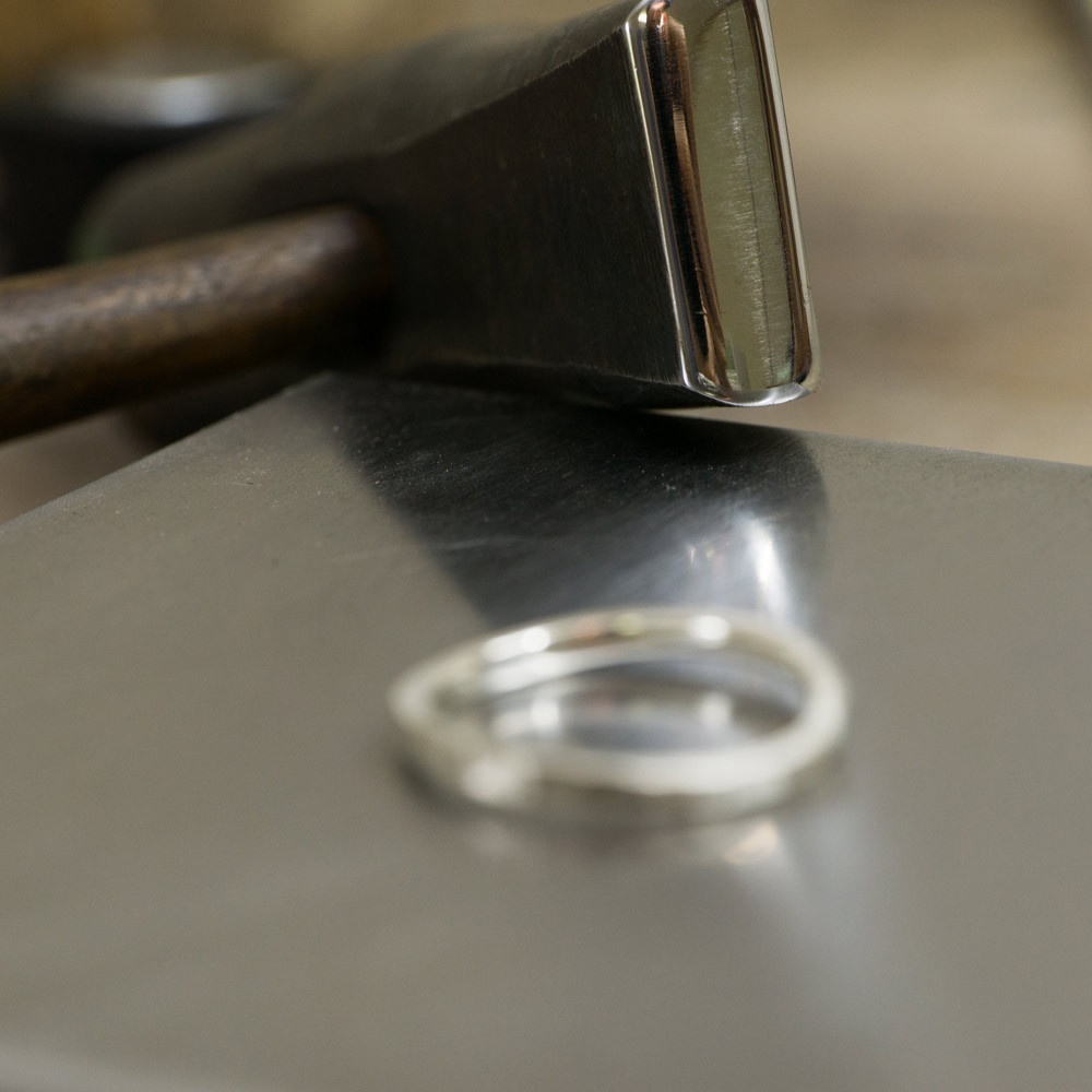 ジュエリーの制作風景　金槌、その奥にシルバーのリング　屋久島で作る結婚指輪