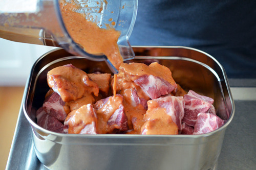 Pouring the paleo marinade over the cubed pork shoulder to make Peachy Pork-a-Bobs with Whole30-friendly BBQ sauce
