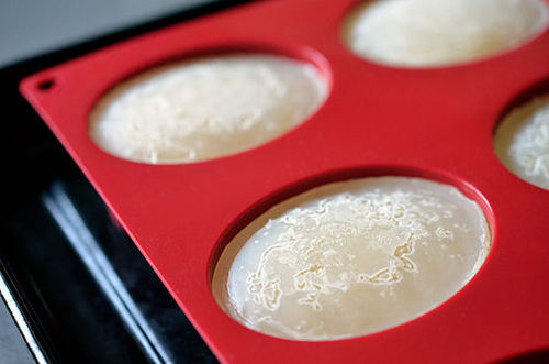 A closeup shot of frozen bone broth in a red silicone mold.