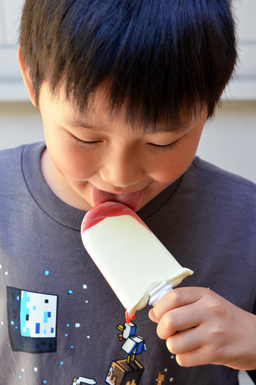 A young child eating a lava flow ice pop.
