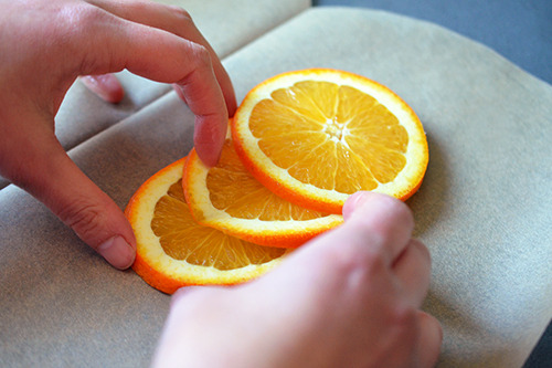 Laying three slices of orange on one half of the parchment paper heart. 