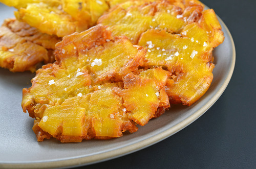 Close up of paleo fried green plantains topped with salt on a plate.