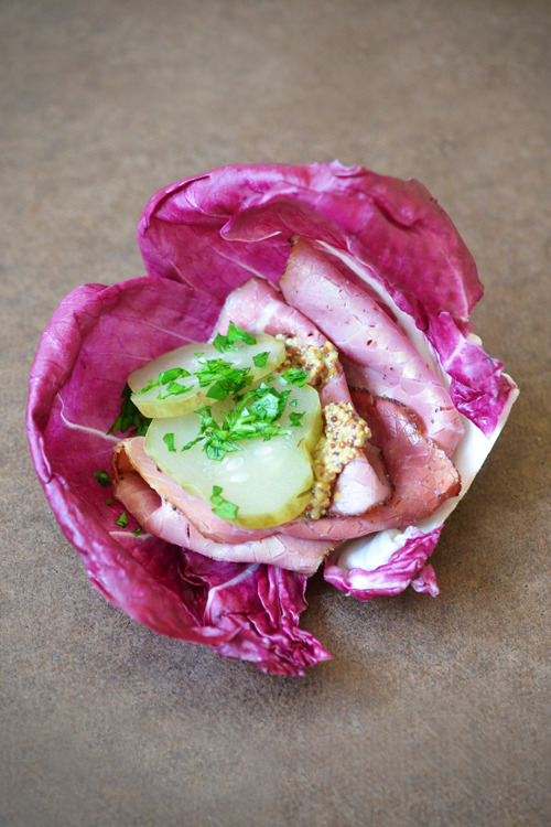 A radicchio wrap with pickles and prosciutto.