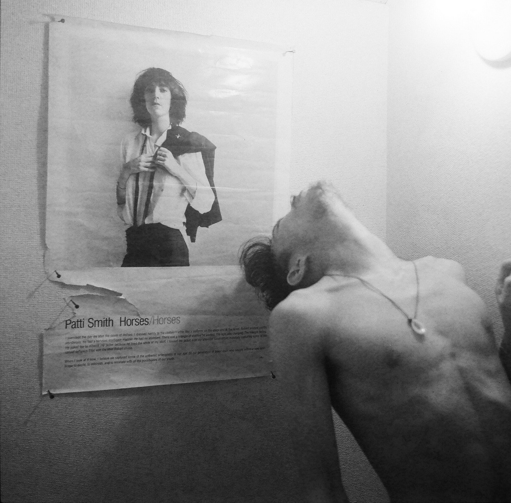 Robert Mapplethorpe in front of his cover for Patti Smith’s Horses c.1975