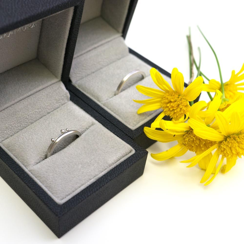 ケースに入ったプラチナの結婚指輪　その隣に屋久島のツワブキの花