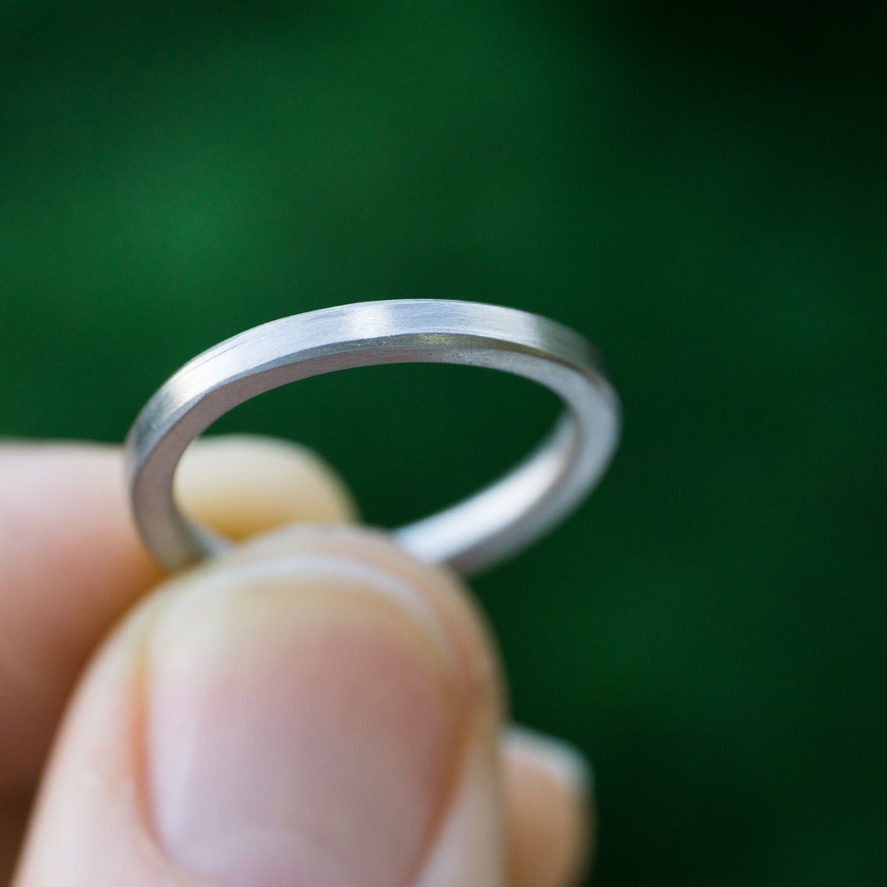 屋久島の緑バック　ホワイトゴールドのリング　指輪を手に取る