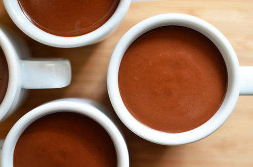 An overhead shot of several Mexican chocolate pots de crème in white mugs.