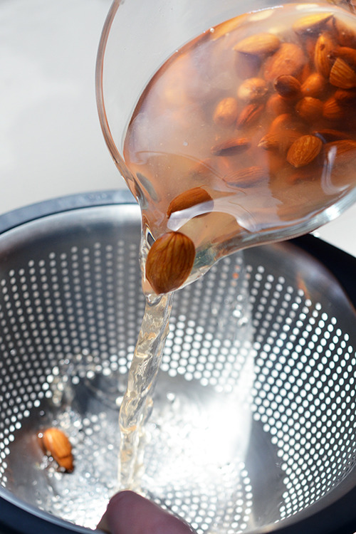 Dumping the soaked almonds into a colander.