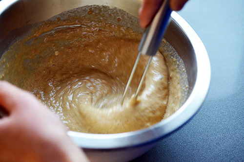 The wet and dry paleo pancake ingredients are whisked together in a mixing bowl.