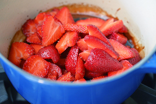 Thinly sliced strawberries added to a pot with reduced balsamic vinegar.