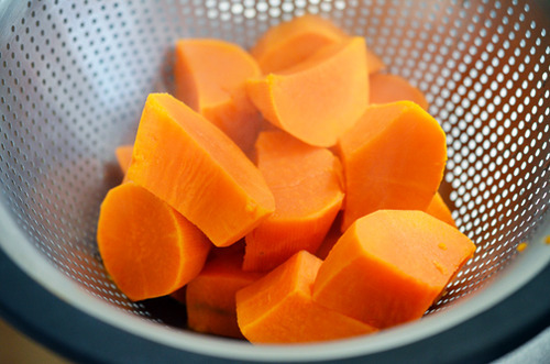 Cooked and drained sweet potatoes in a strainer.