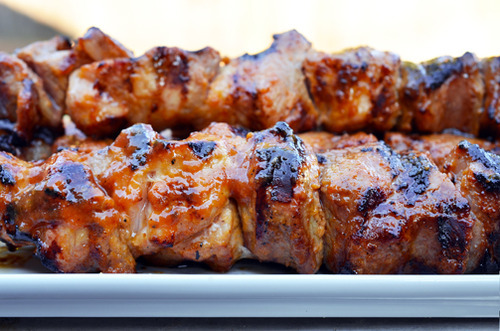 A side view of a platter of Peachy Pork-a-Bobs, grilled pork skewers with spicy peach barbecue sauce
