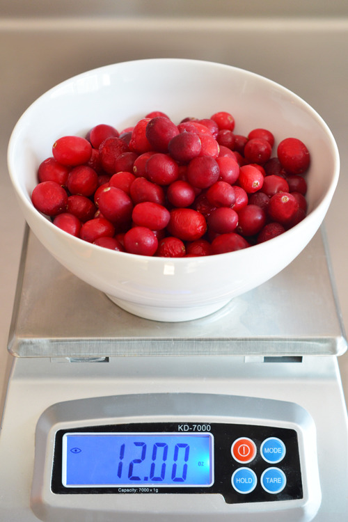 Measuring out the weight of the cherries and cranberries for paleo cran-cherry sauce.