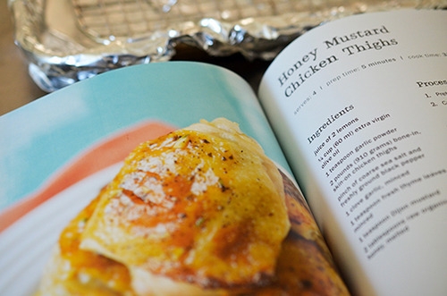 The Paleo Kitchen book opened up to the honey mustard chicken thigh recipe page.