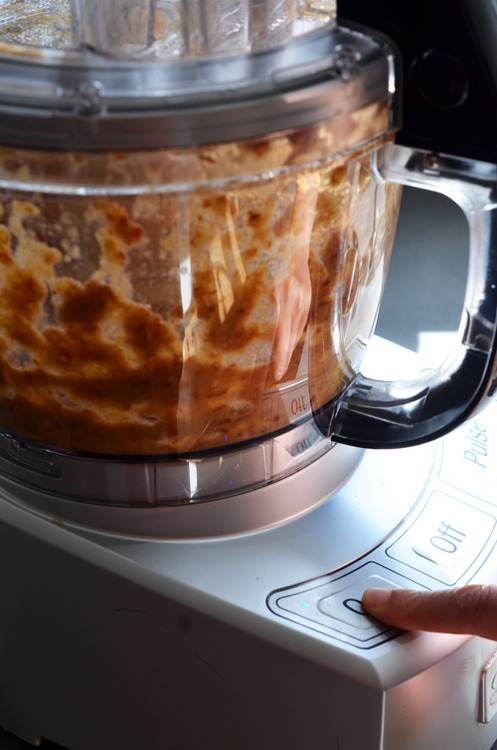 A side view of a food processor that is blending the wet ingredients for Tropical Paleo Granola