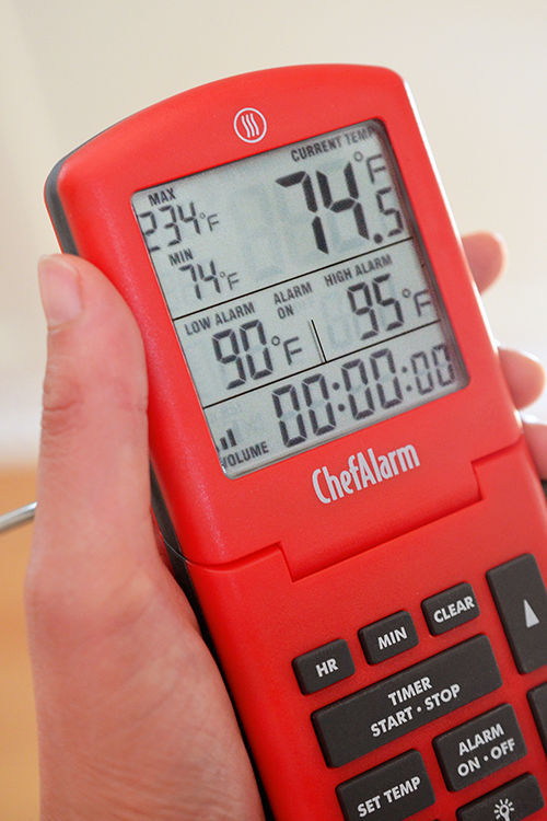 A closeup of the display on a red Thermoworks ChefAlarm in-oven thermometer.