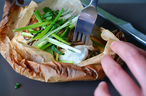 A fork stabbing into Fish en Papillote with Citrus, Ginger, & Shiitake 