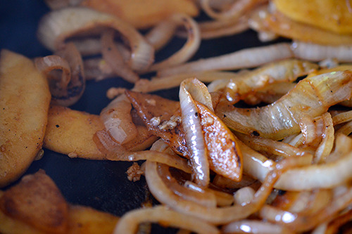 Sautéed onions and apples in a cast iron skillet.