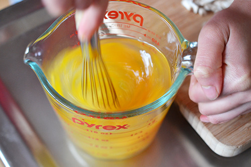 The eggs, water, and fish sauce are whisked in a measuring cup.