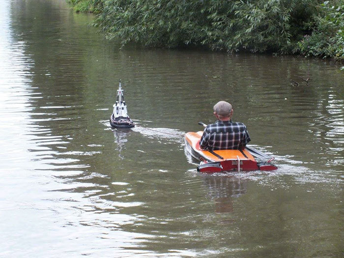 rc tugboat tows man in kayak down english canal...