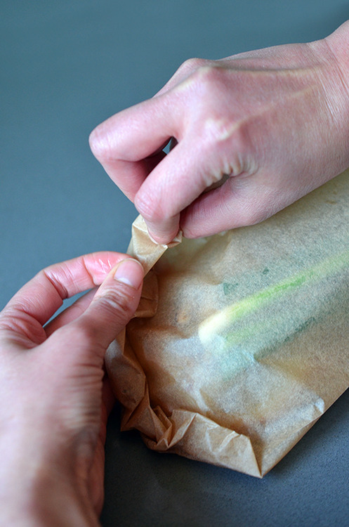 Crimping the edges of the parchment paper to seal the Fish en Papillote (in Parchment) with Citrus, Ginger, & Shiitake 