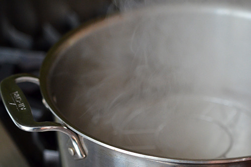 An shot of an open pot with steaming water inside.