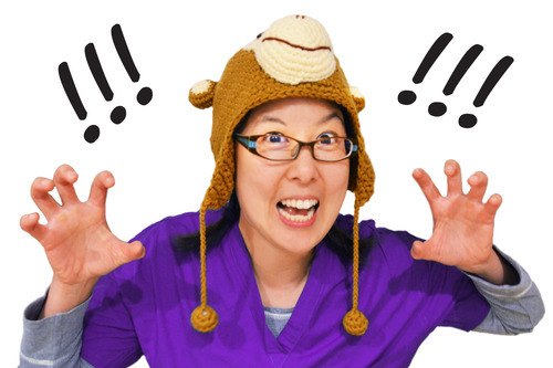 An Asian woman with a monkey hat growling at the camera